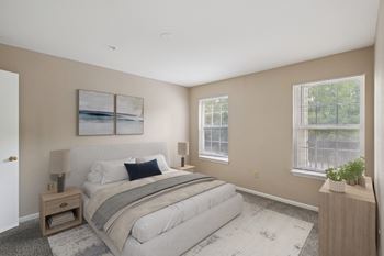 A bedroom with a large bed and a painting on the wall.